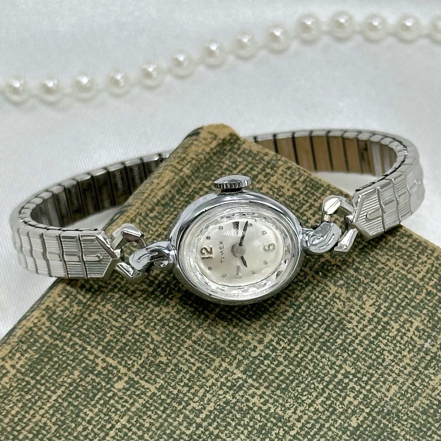 Vintage silver tone manual winding Timex watch with detailed stretchable band and diamanté dial.