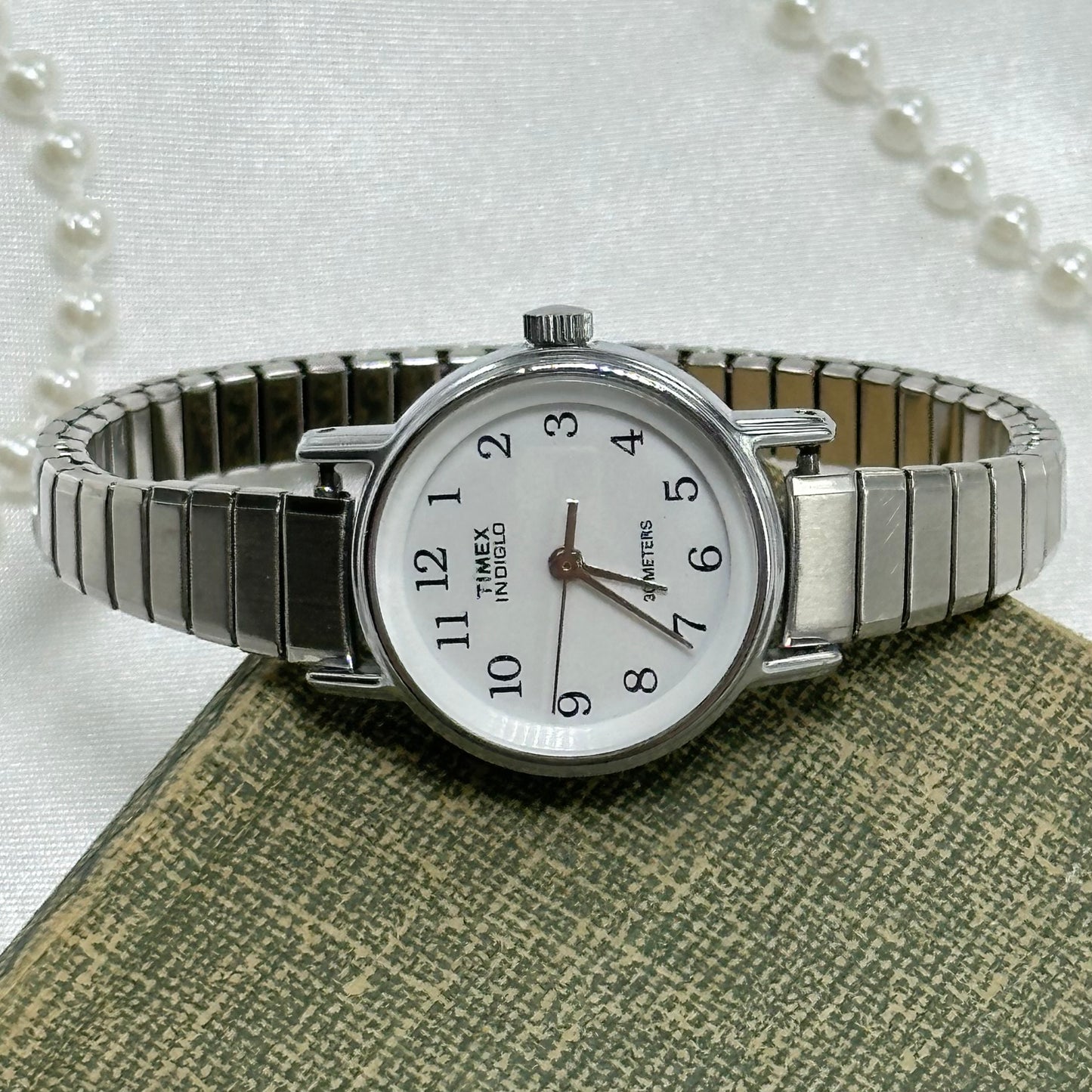 Vintage silver tone water resistant Timex Indigo watch with quartz movement and stretchable band.