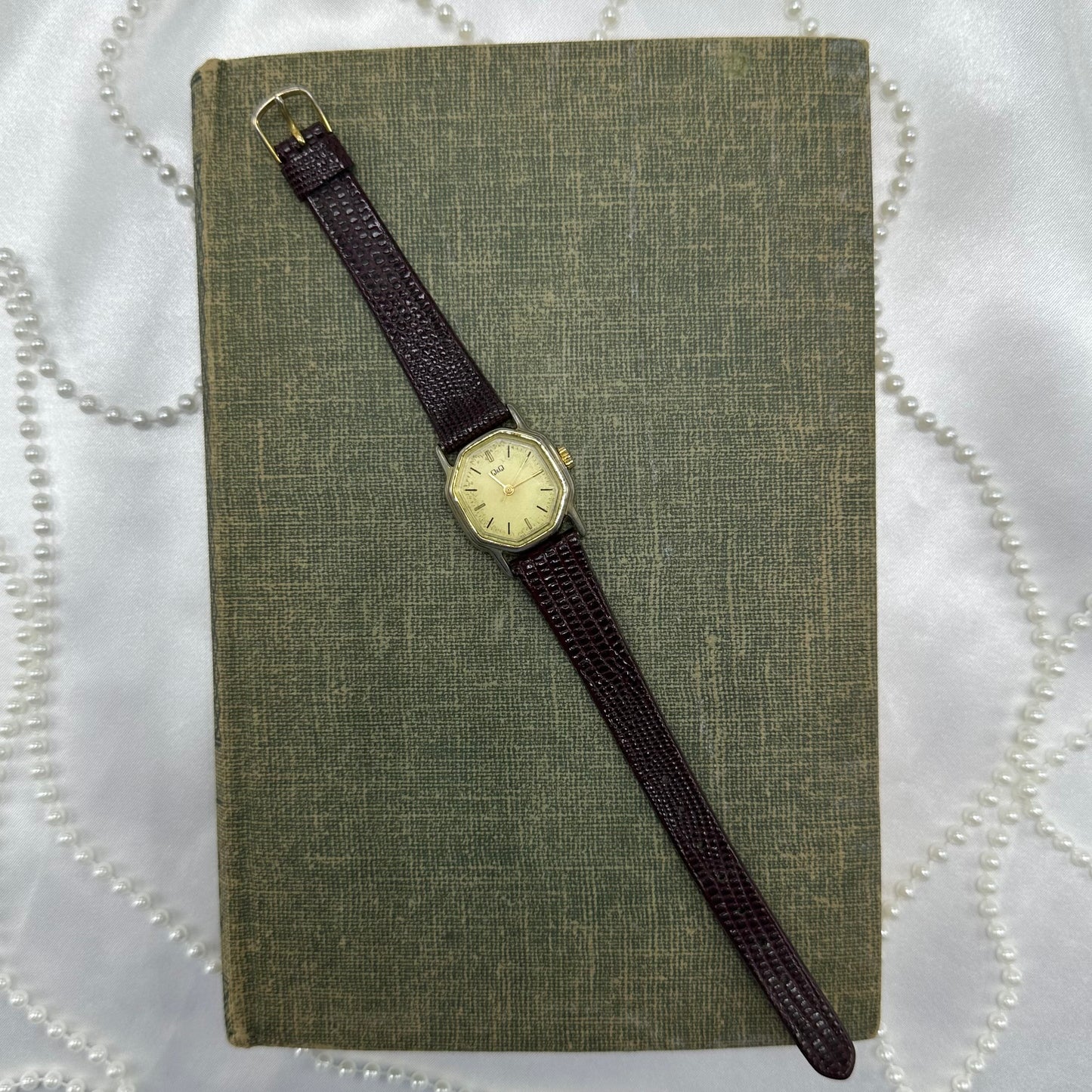 Classic gold tone Q&Q watch with brown leather strap.