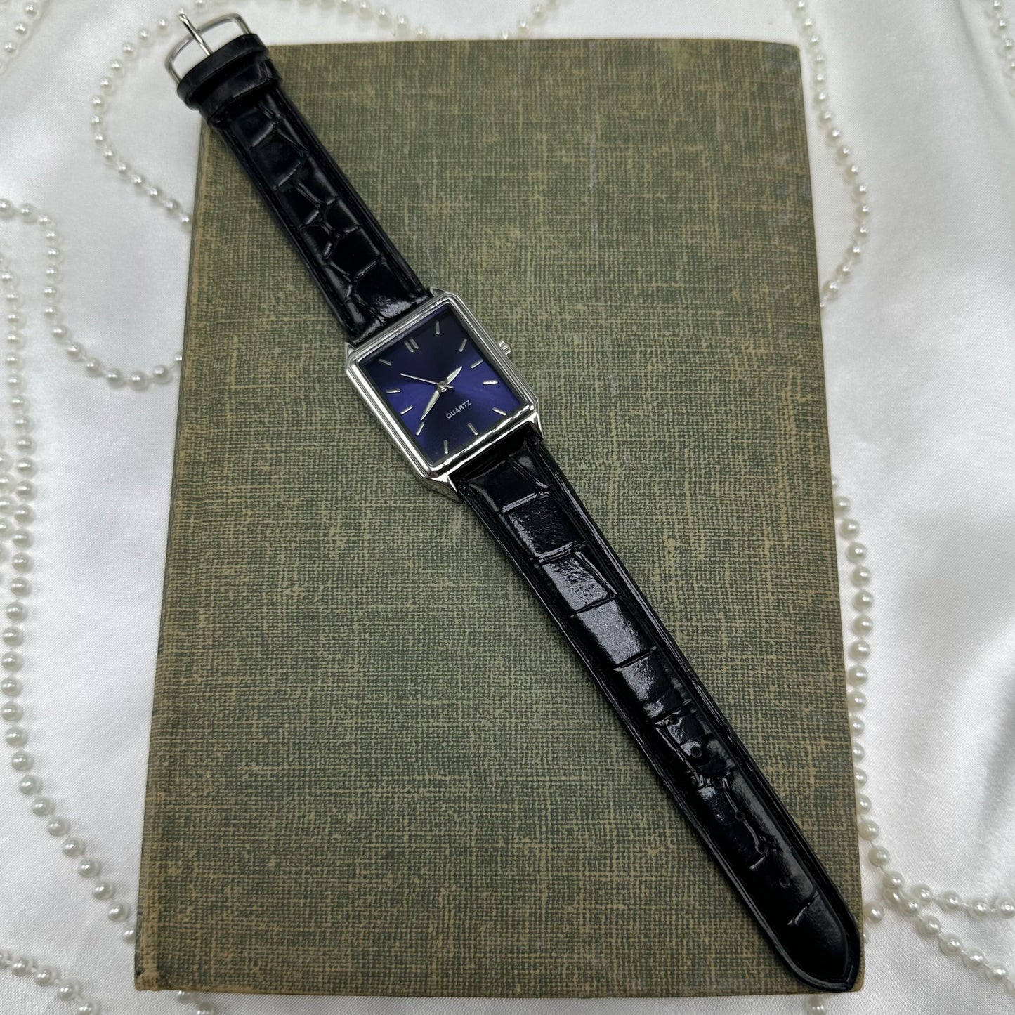 Silver tone watch with dark blue dial and black leather band.