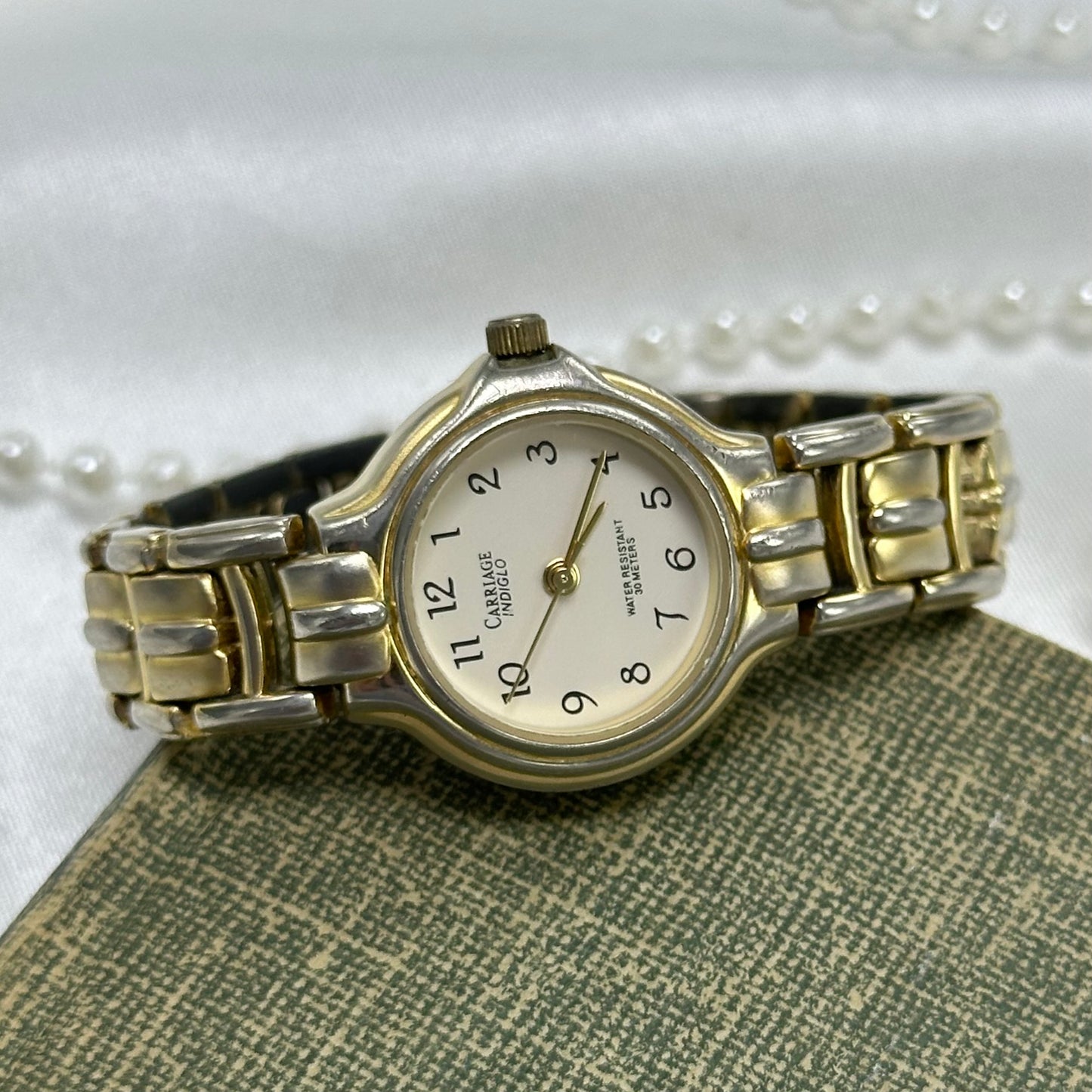 Gold and silver tone Carriage Indiglo watch with quartz movement. Water resistant (30M). Dial glows when crown is pushed in.