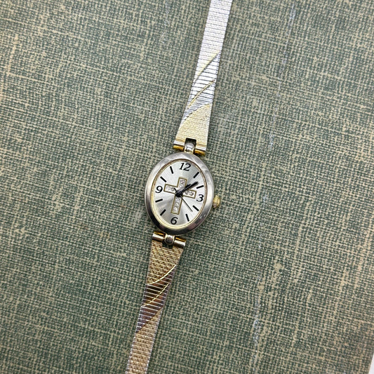 Gold and silver tone diamanté cross watch with quartz movement.