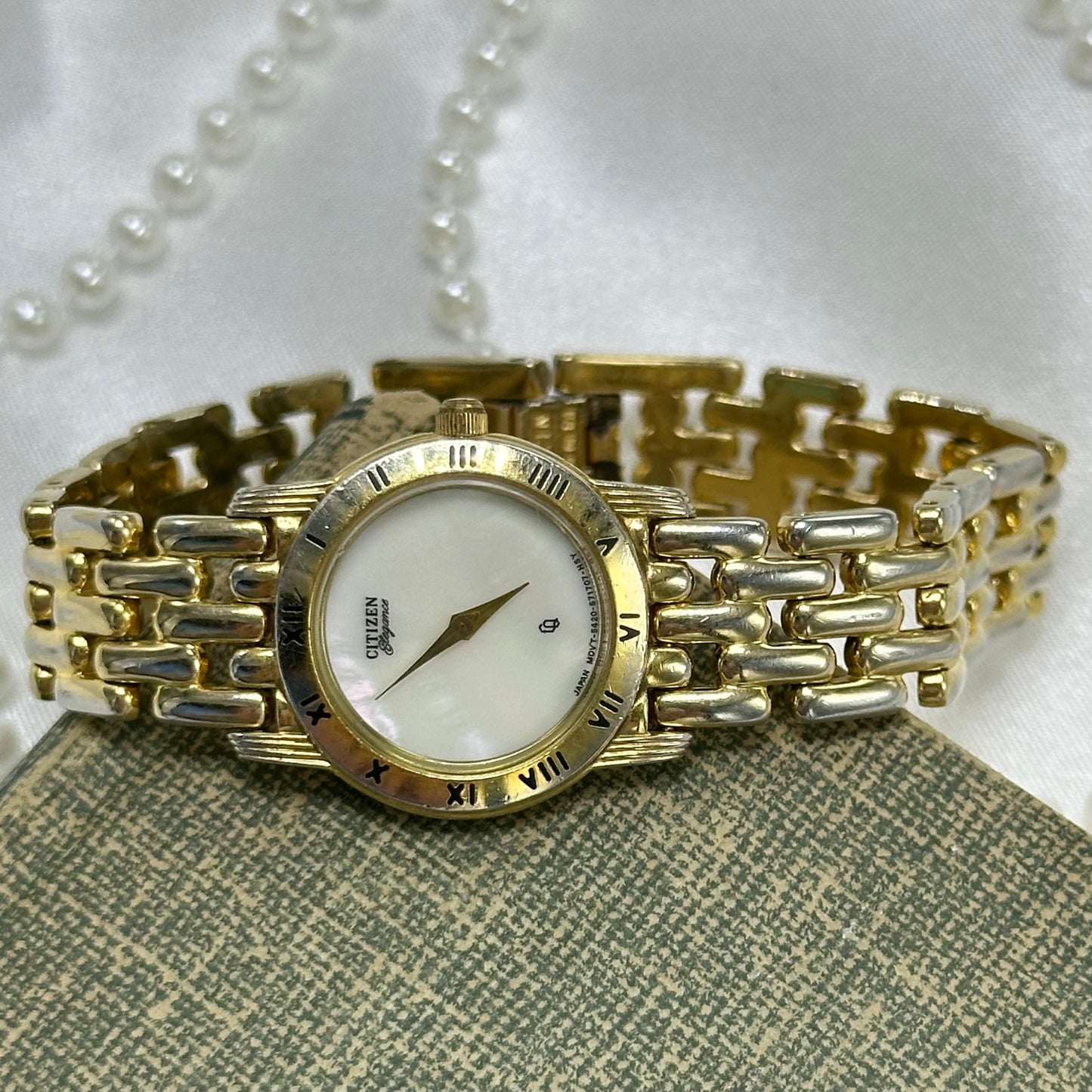 Gold tone Citizen Elegance watch with mother of pearl dial and roman numeral markers.