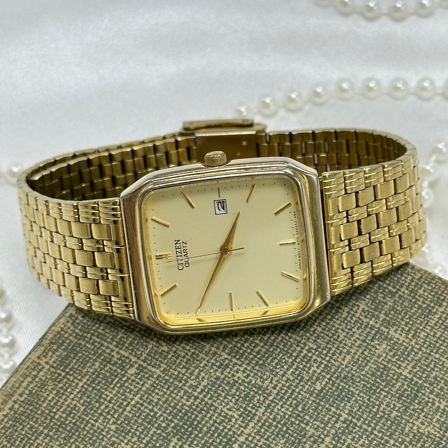 Gold tone Citizen square dial watch with date display and quartz movement.