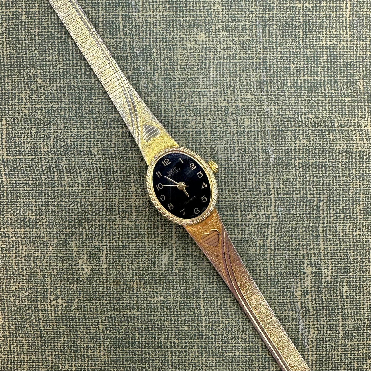 Gold tone Sarah Coventry heart watch with black dial and quartz movement.