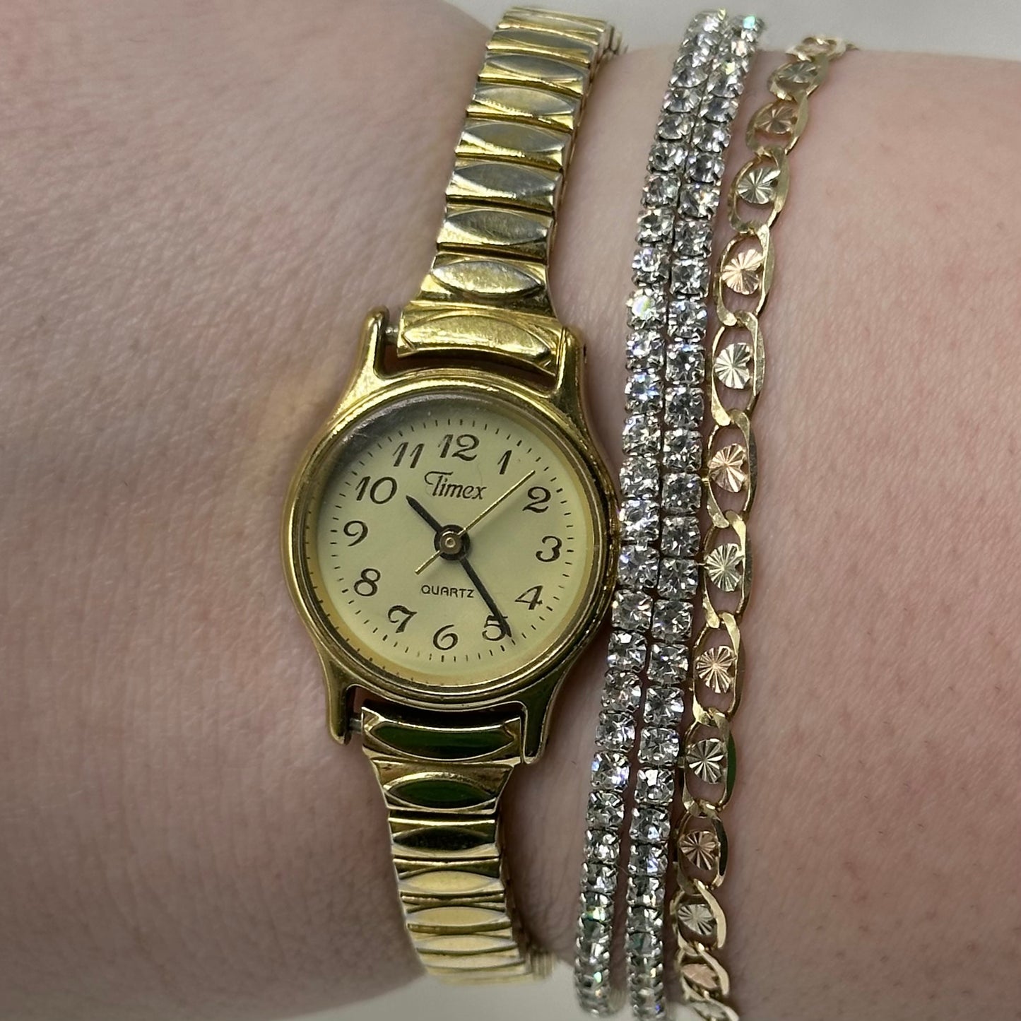 Gold tone Timex watch with quartz movement and stretchable band.