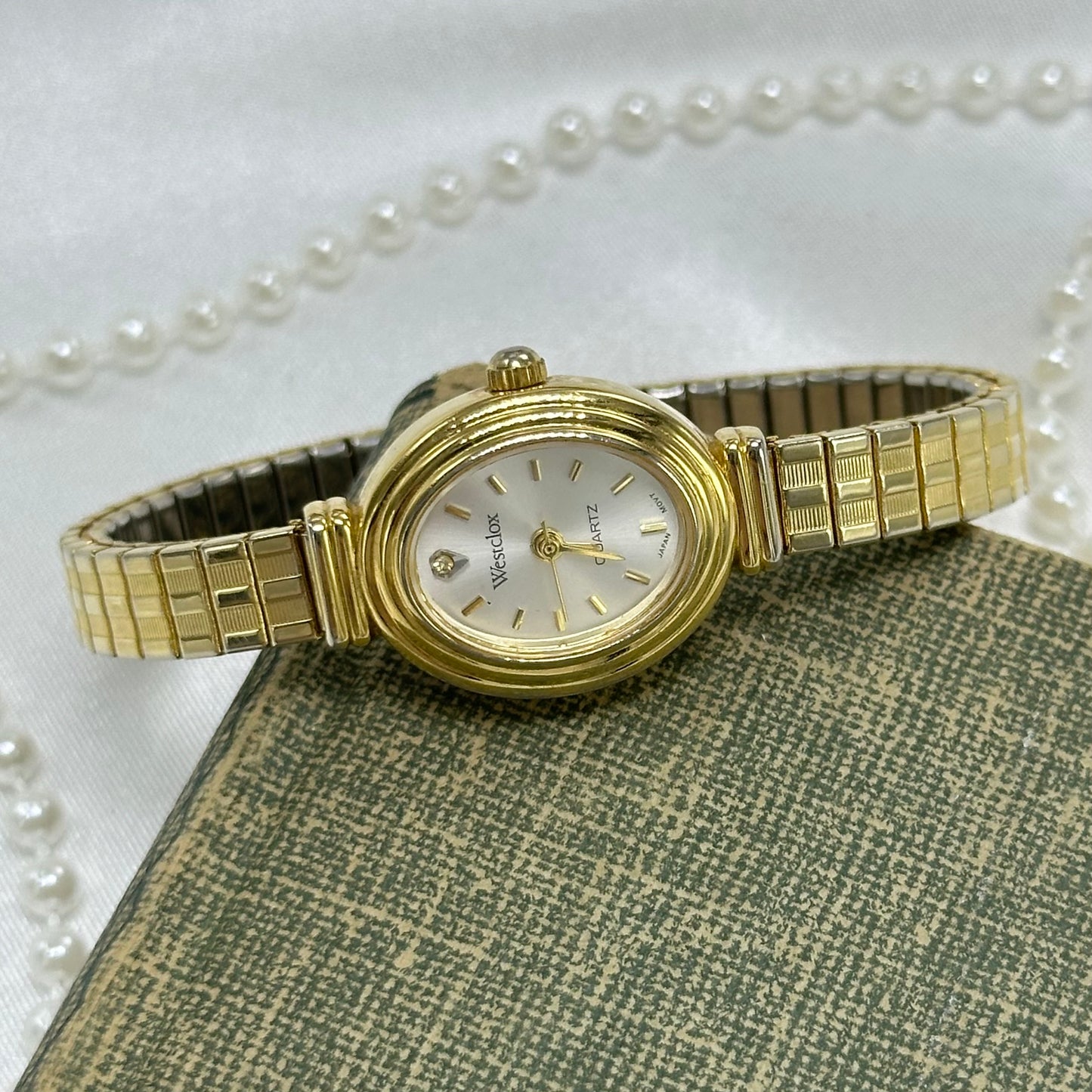 Gold tone Westclox oval dial watch with stretchable band and quartz movement.