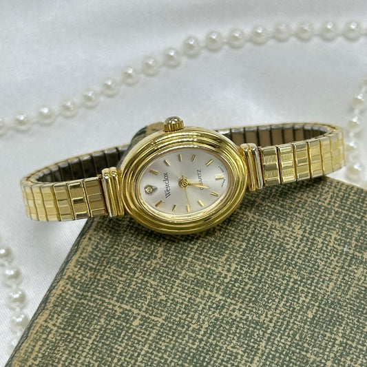 Gold tone Westclox oval dial watch with stretchable band and quartz movement.