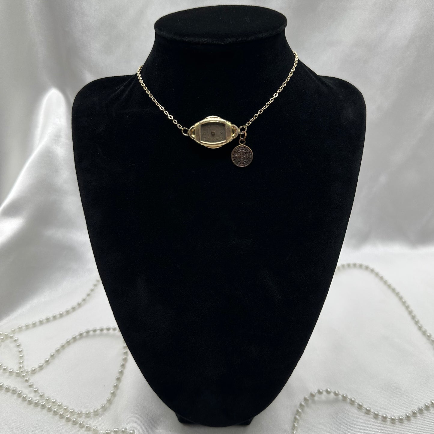 Gold tone choker necklace with vintage watch and Saint Benedict medal.