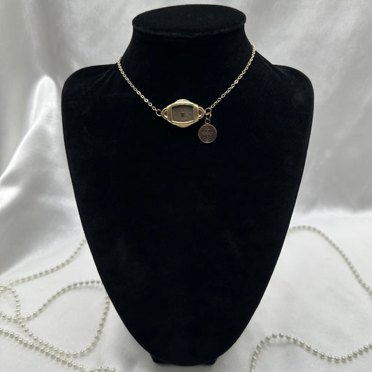 Gold tone choker necklace with vintage watch and Saint Benedict medal.