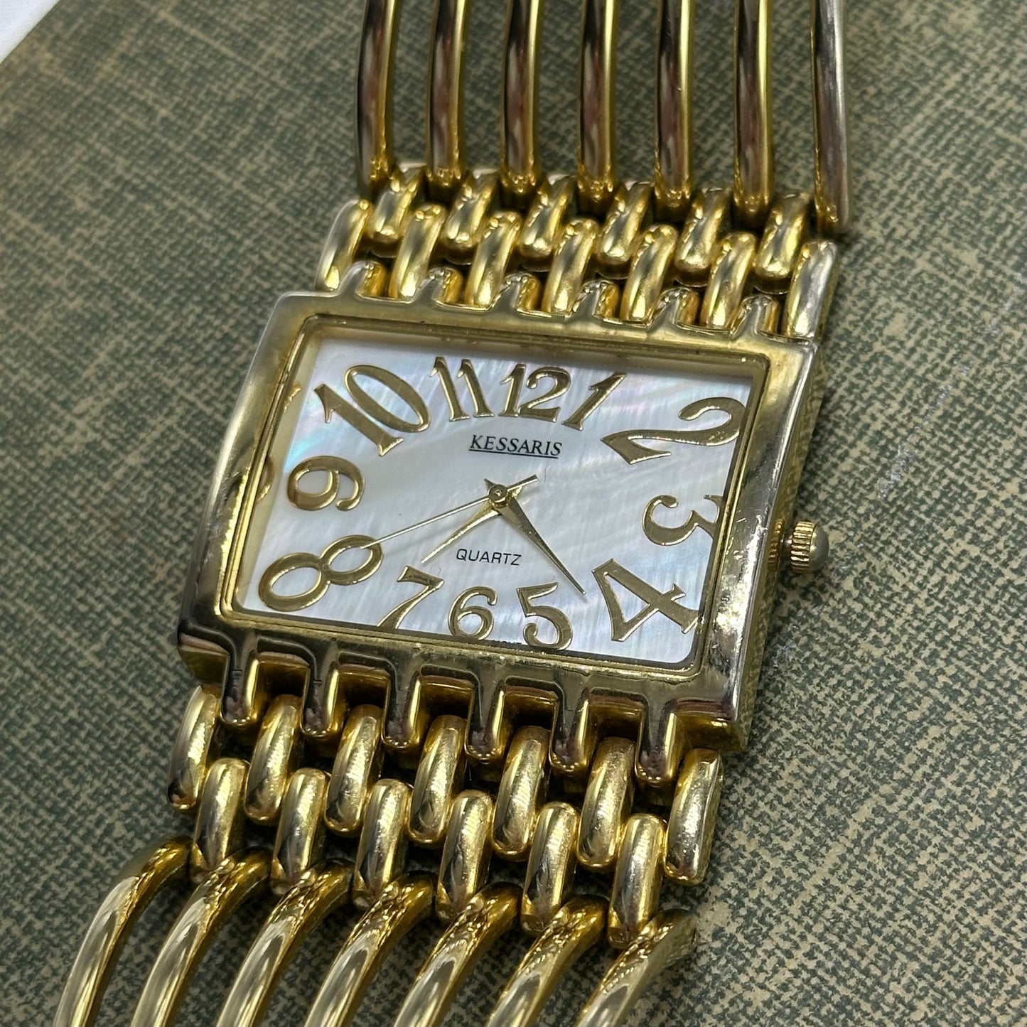 Gold tone chunky cuff watch with quartz movement and mother of pearl