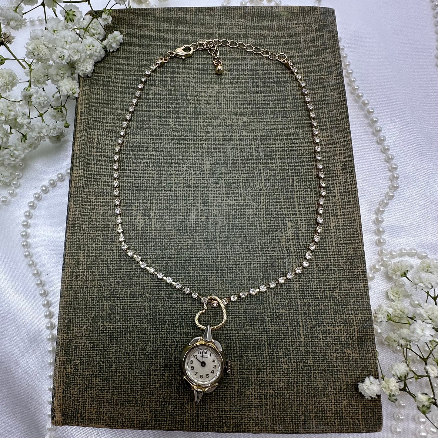 Gold tone rhinestone necklace with heart bail and vintage watch pendant.