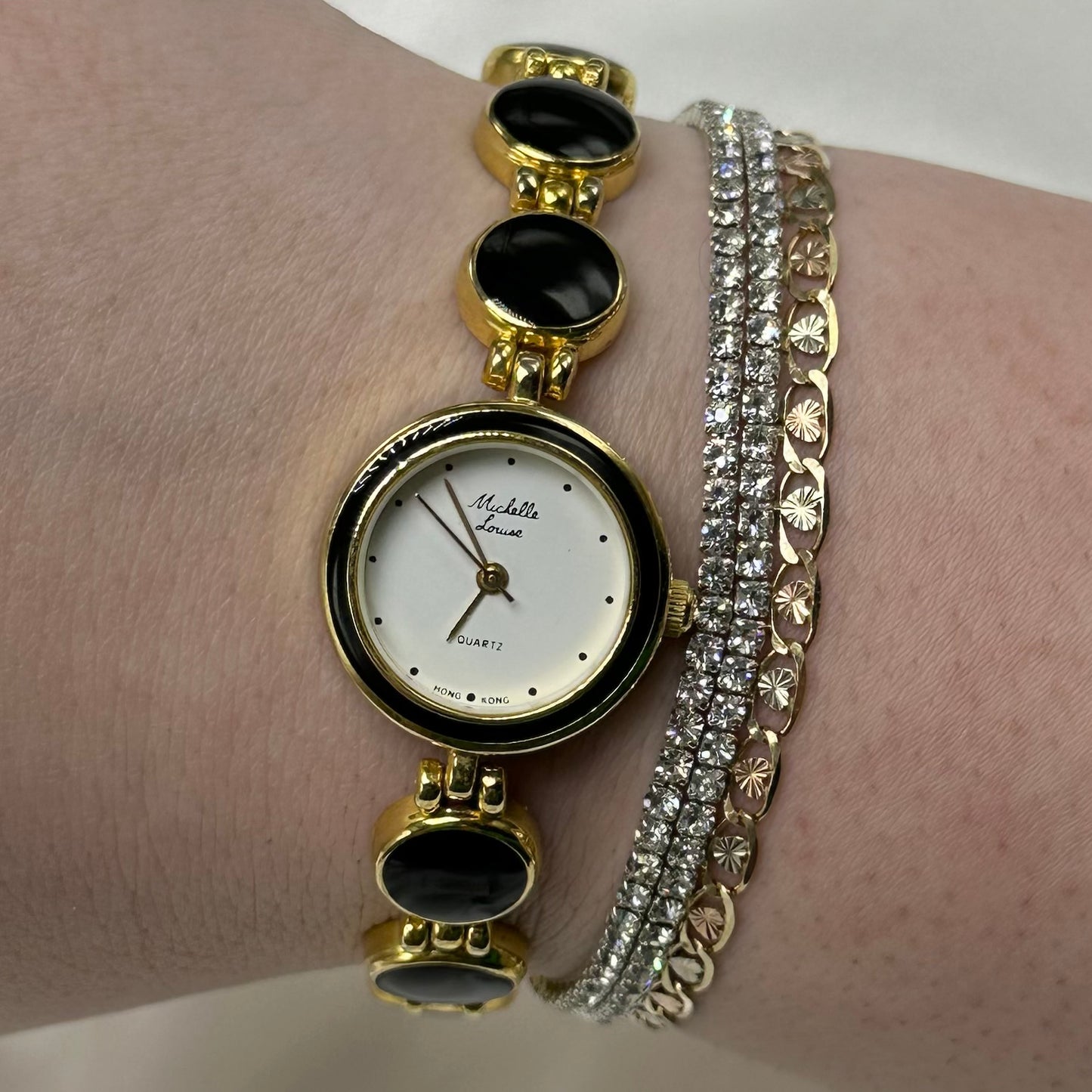 Gold tone round dial watch with quartz movement and clasp band