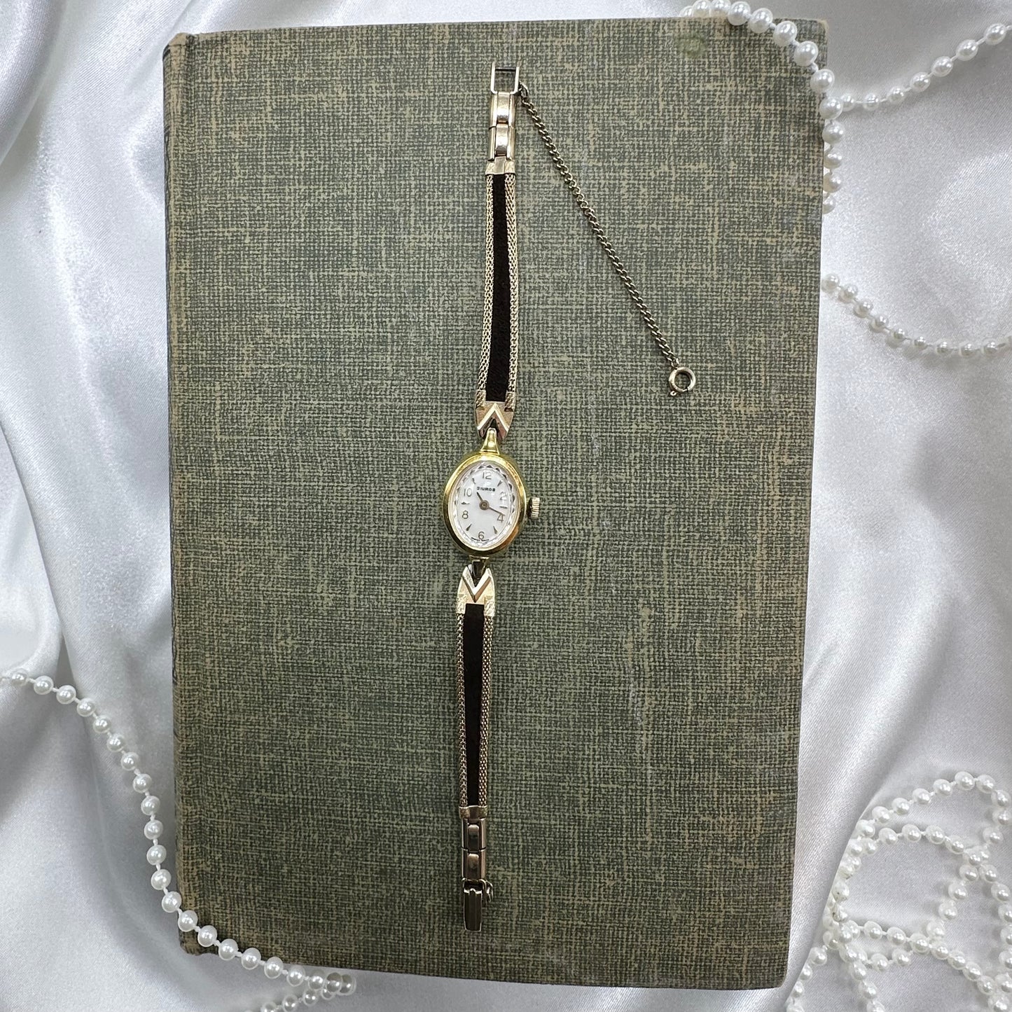 Gold tone watch with black velvet band.