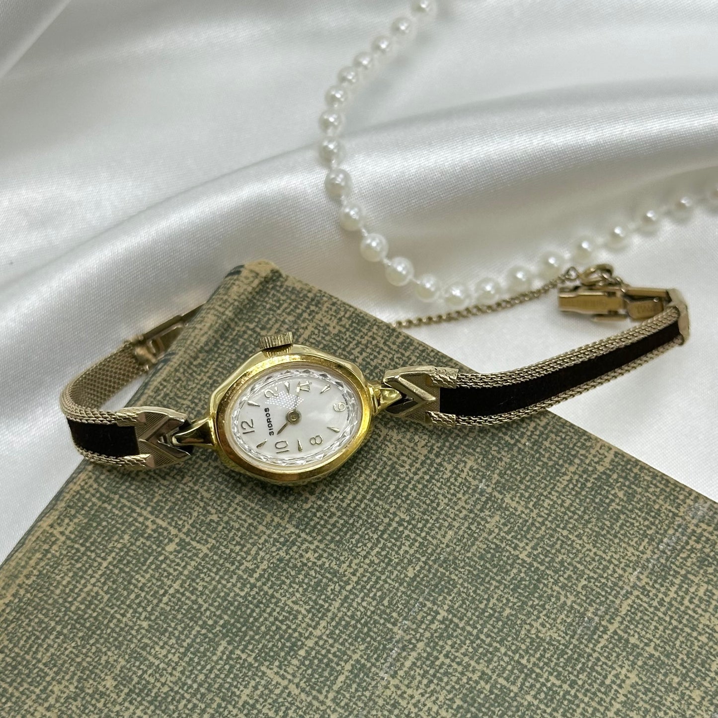 Gold tone watch with black velvet band.