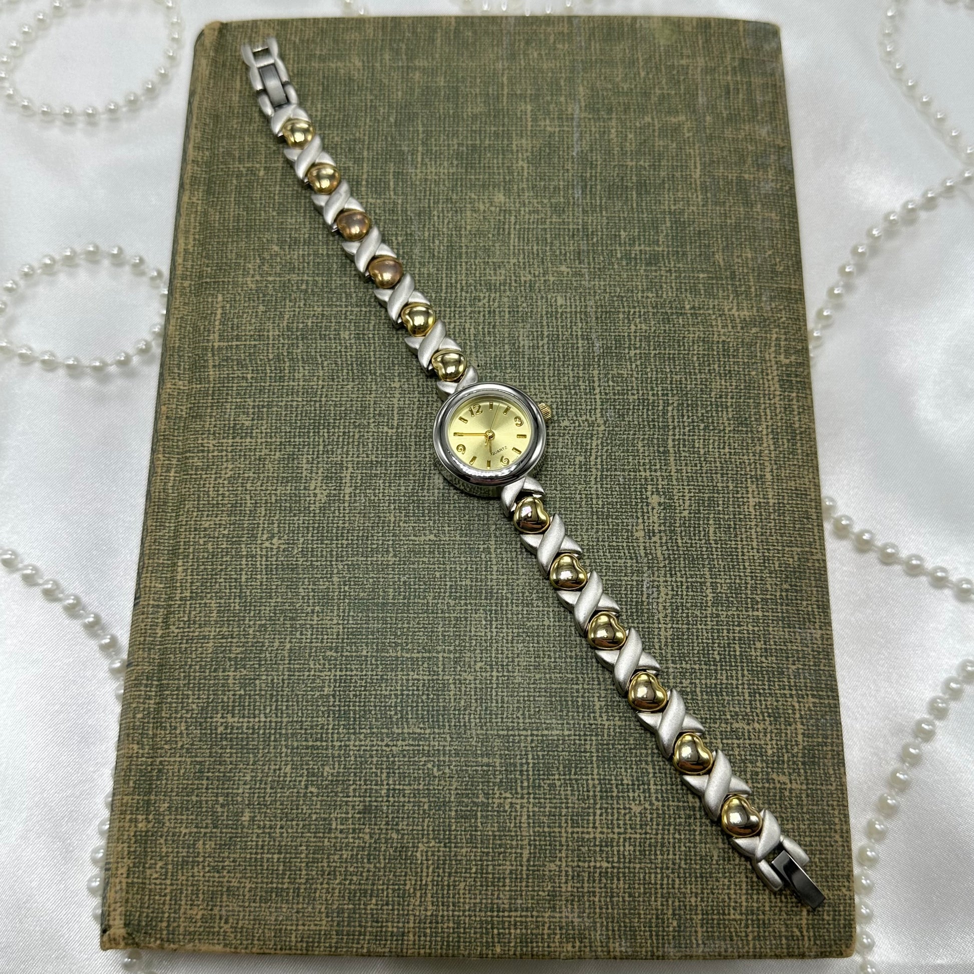 Silver and gold tone Faded Glory watch with unique heart bracelet band and quartz movement.