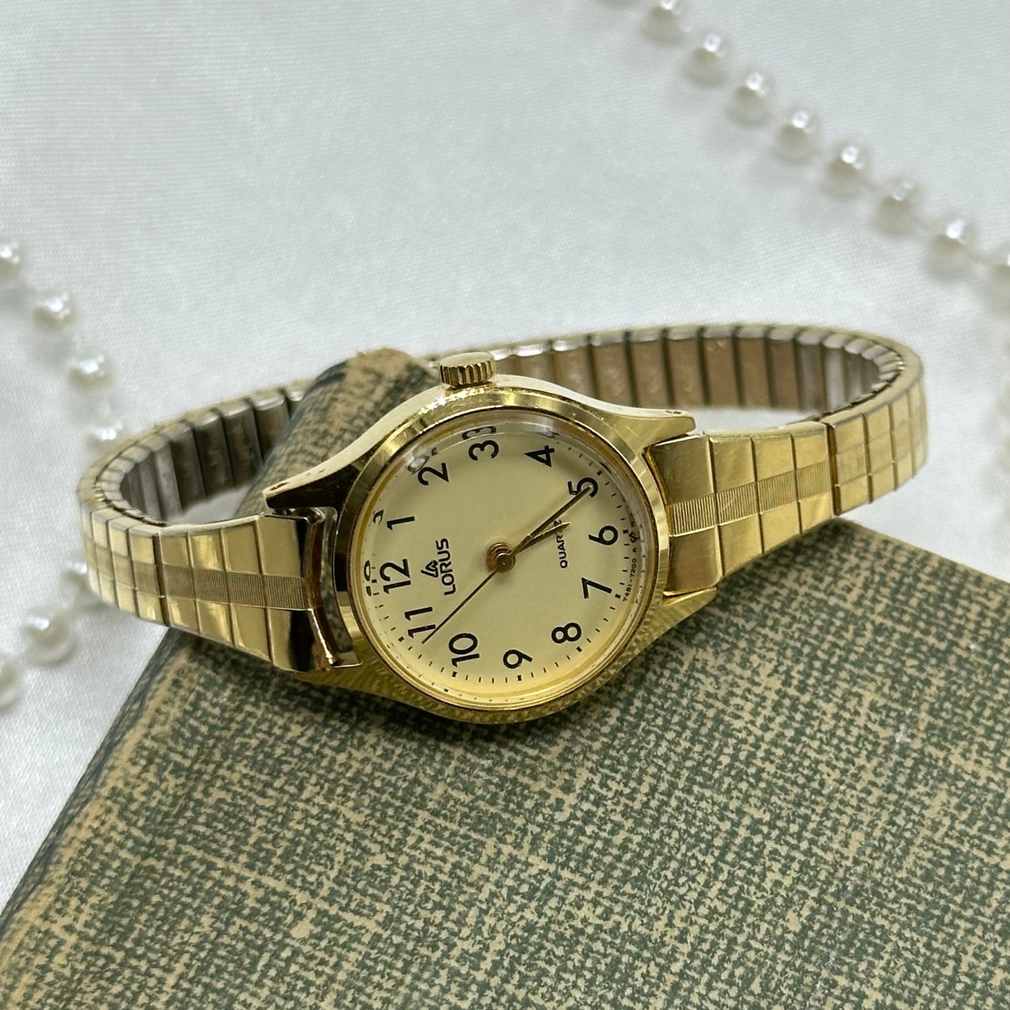 Simple classic gold tone Lorus watch with round dial and stretchable band.