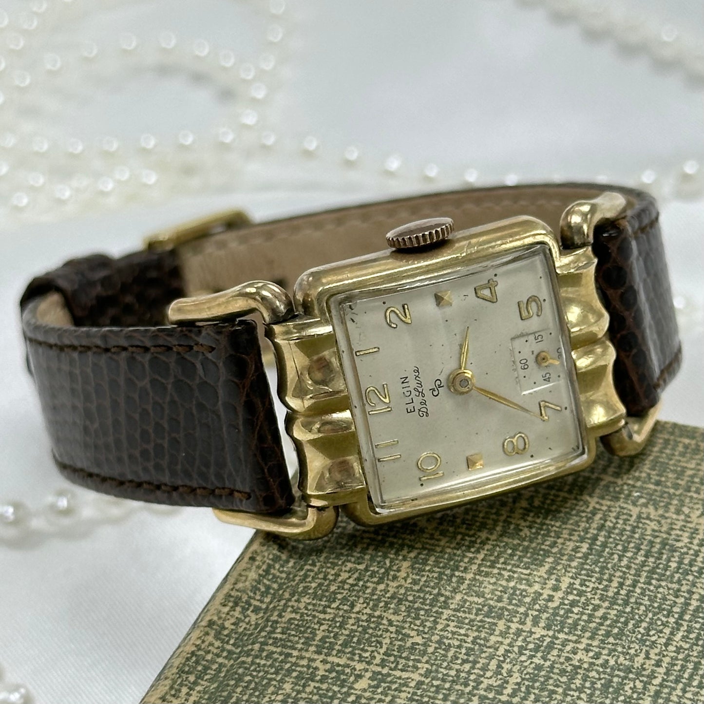 Vintage 10k gold filled manual winding Elgin De Luxe Watch with brown leather band and unique square dial.