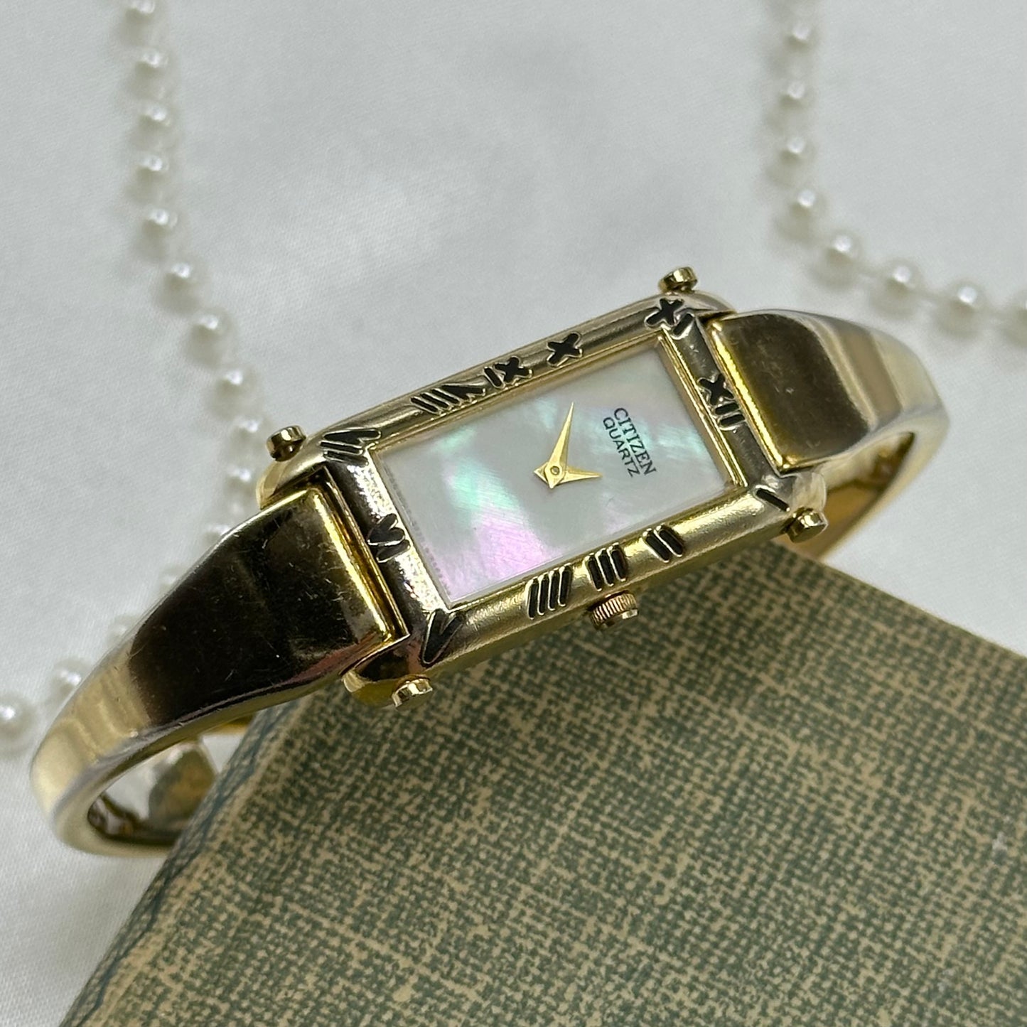 Vintage Citizen gold tone cuff watch with mother of pearl dial and clasp band.
