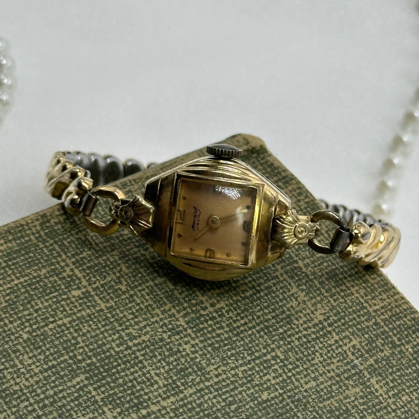 Vintage Howard ACH 10k rolled gold-plated manual winding watch with stretchable band and rose gold dial.