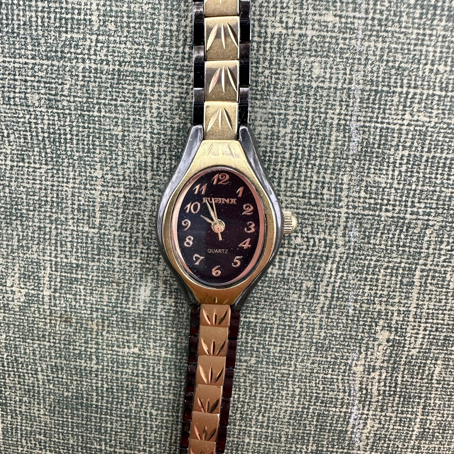 Vintage black and gold tone Elgin II watch with quartz movement and clasp band.