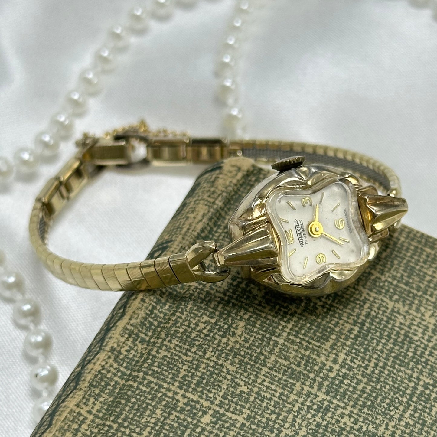 Vintage gold tone 17 jewels manual winding Aureole watch from the 1970's with square pattern detailed band and safety clasp.