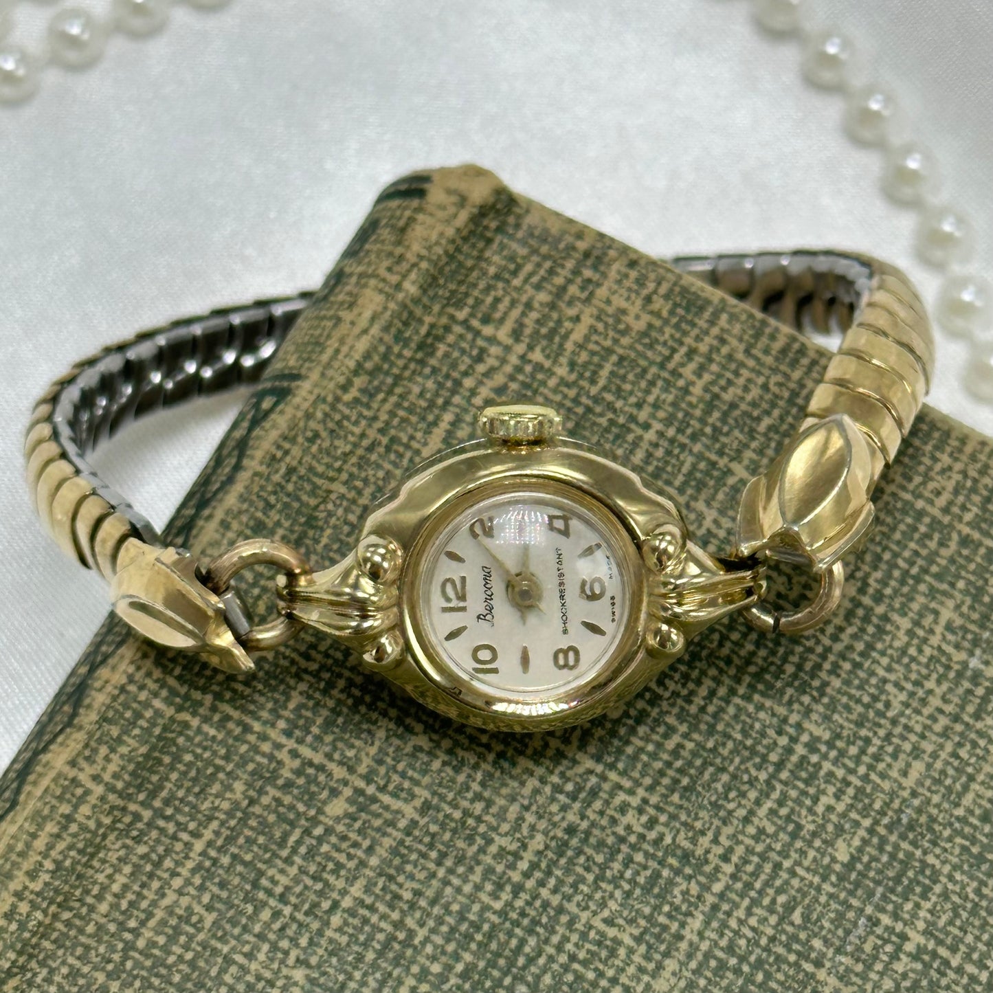Vintage gold tone manual winding Bercona shock resistant Swiss made watch with unique stretchable band and elegant round dial from the 1950's.