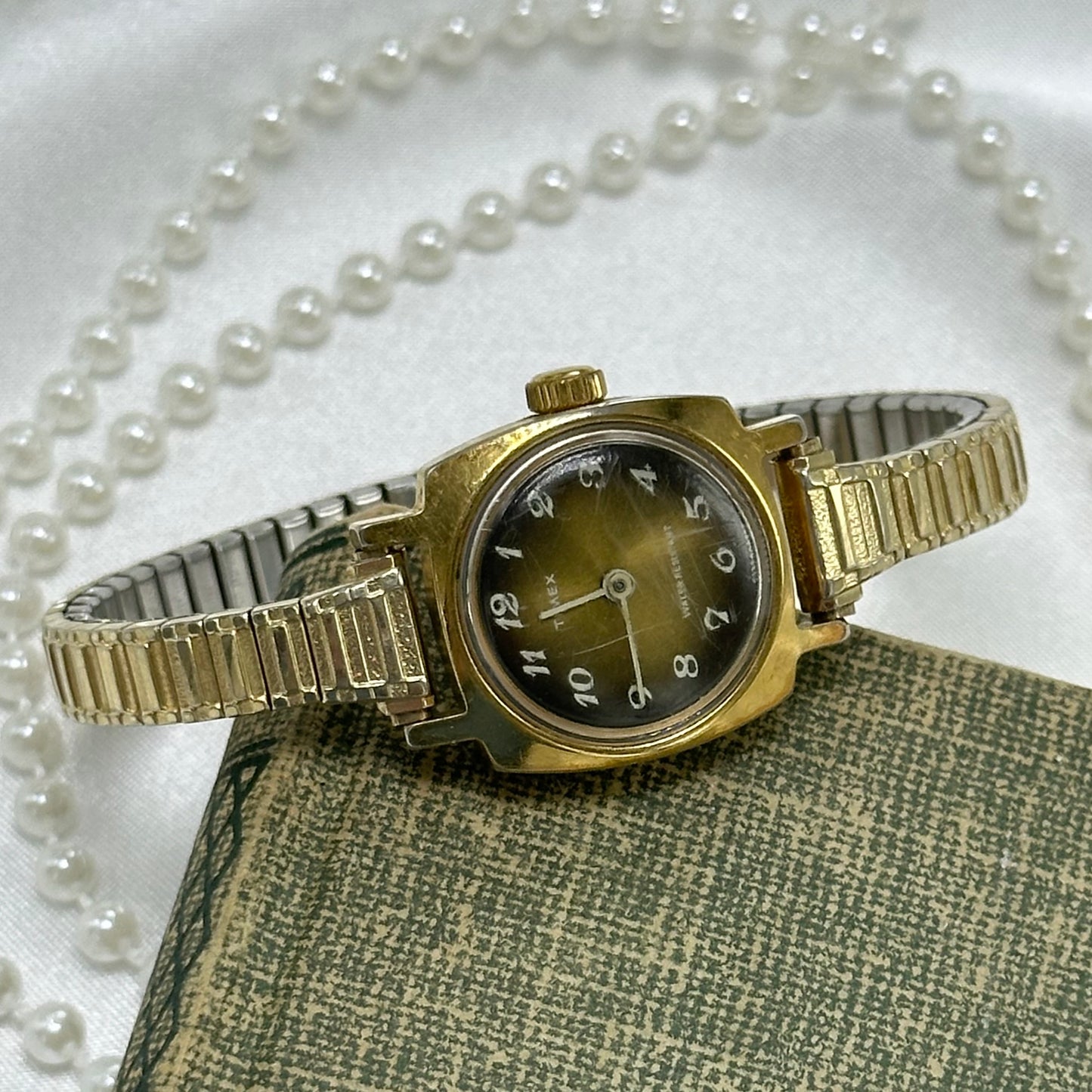Vintage gold tone manual winding Timex watch from the 1970's with unique brown dial and stretchable band. Water resistant.