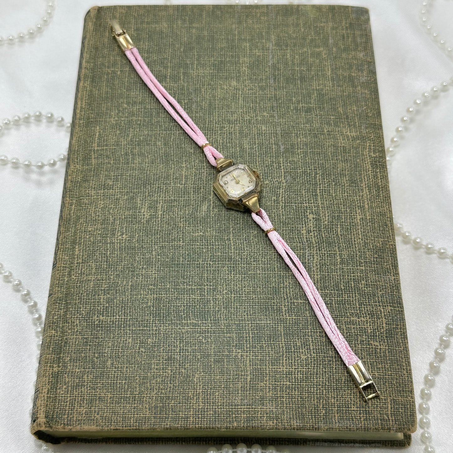 Vintage gold tone manual winding cocktail watch with satin pink band.
