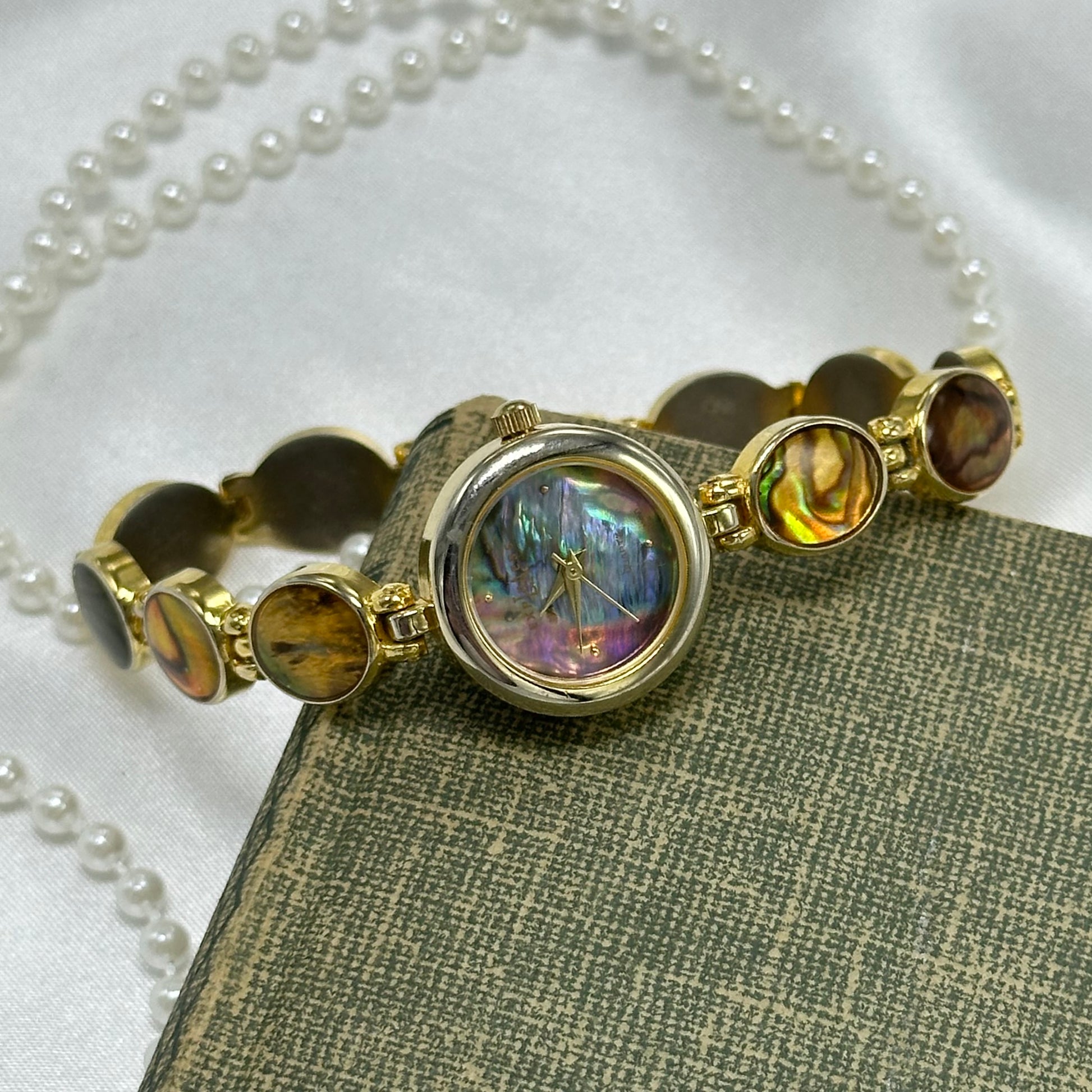 Vintage gold tone round abalone dial LA Express watch with abalone clasp band and quartz movement.