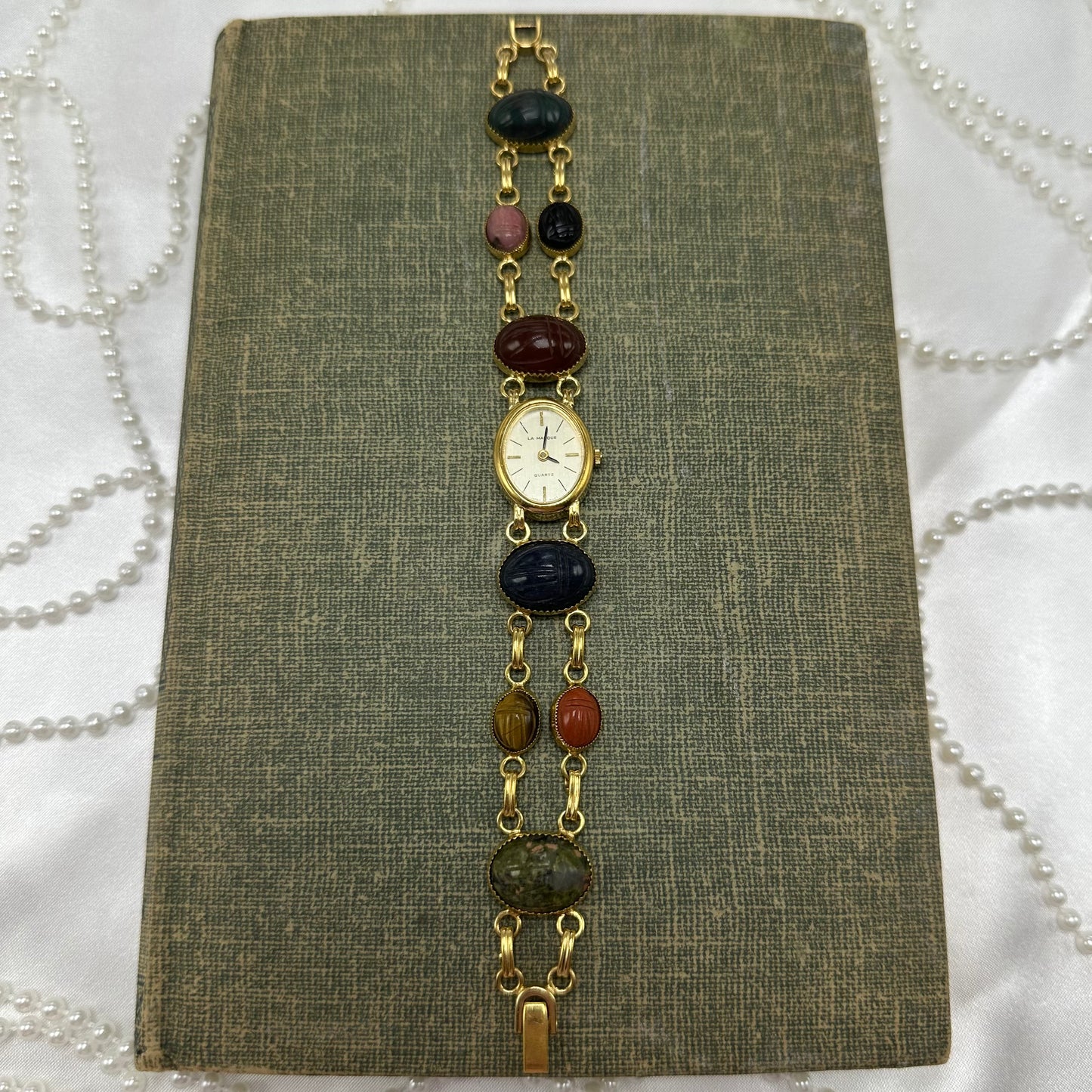 Vintage gold tone scarab watch with quartz movement.