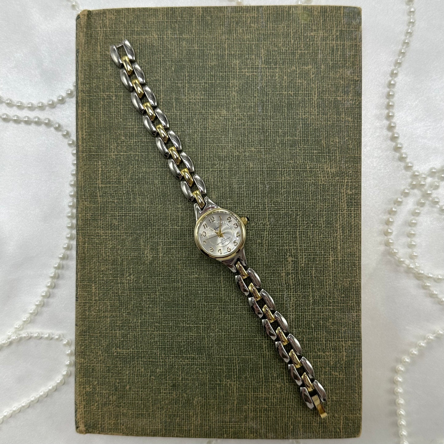 Vintage silver and gold tone Wrangler water resistant watch with blue jewel crown and quartz movement.