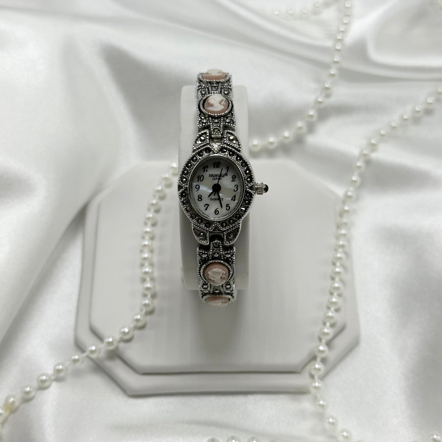 Vintage silver tone cameo watch with mother of pearl dial and blue jewel crown