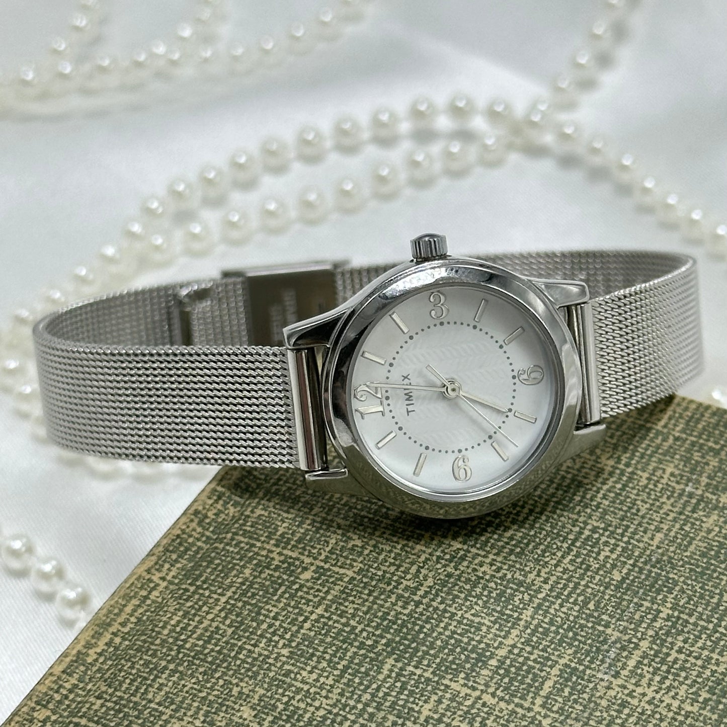 Vintage silver tone round dial Timex with quartz movement and metal mesh band.