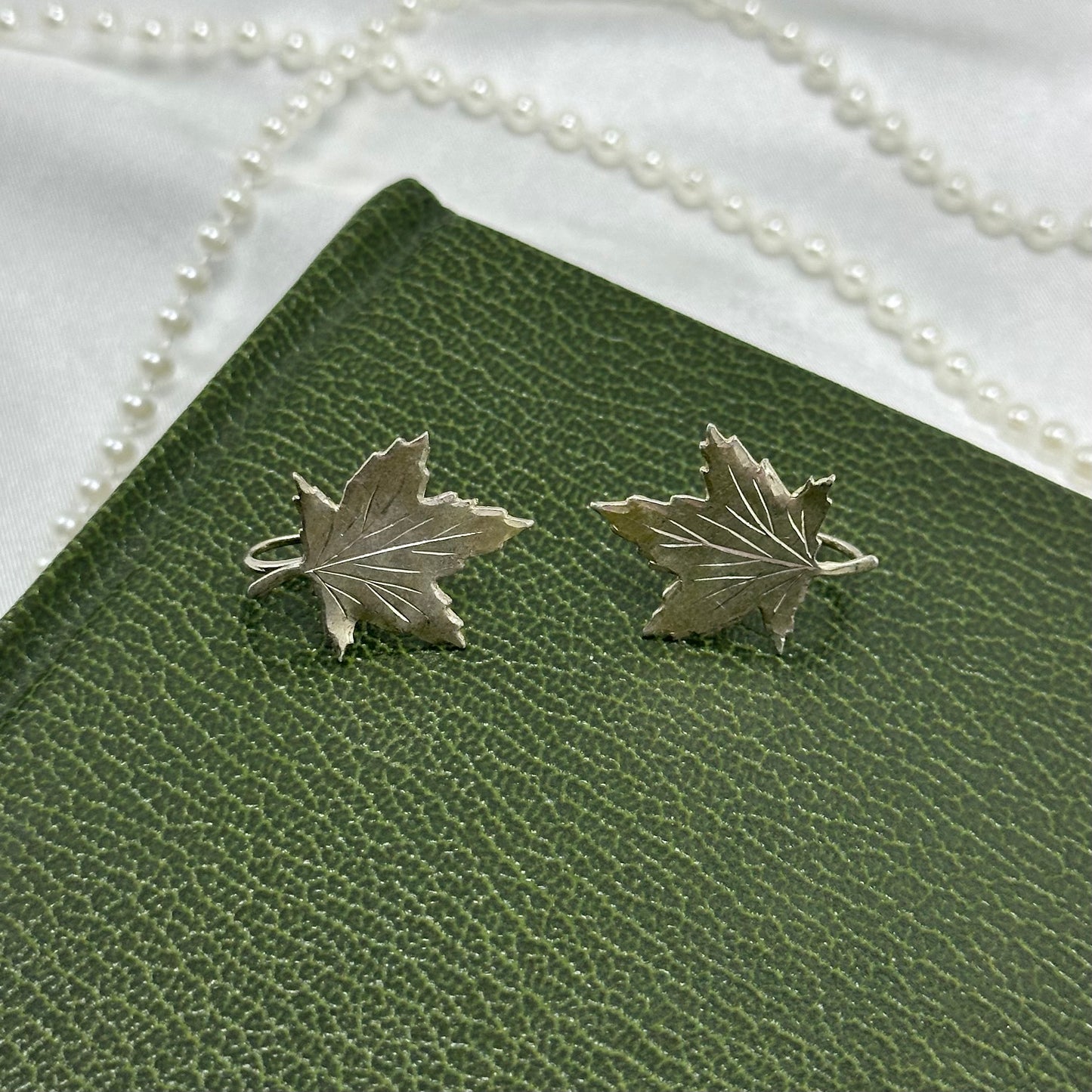 Vintage silver tone clip on screw back earrings with leaves.