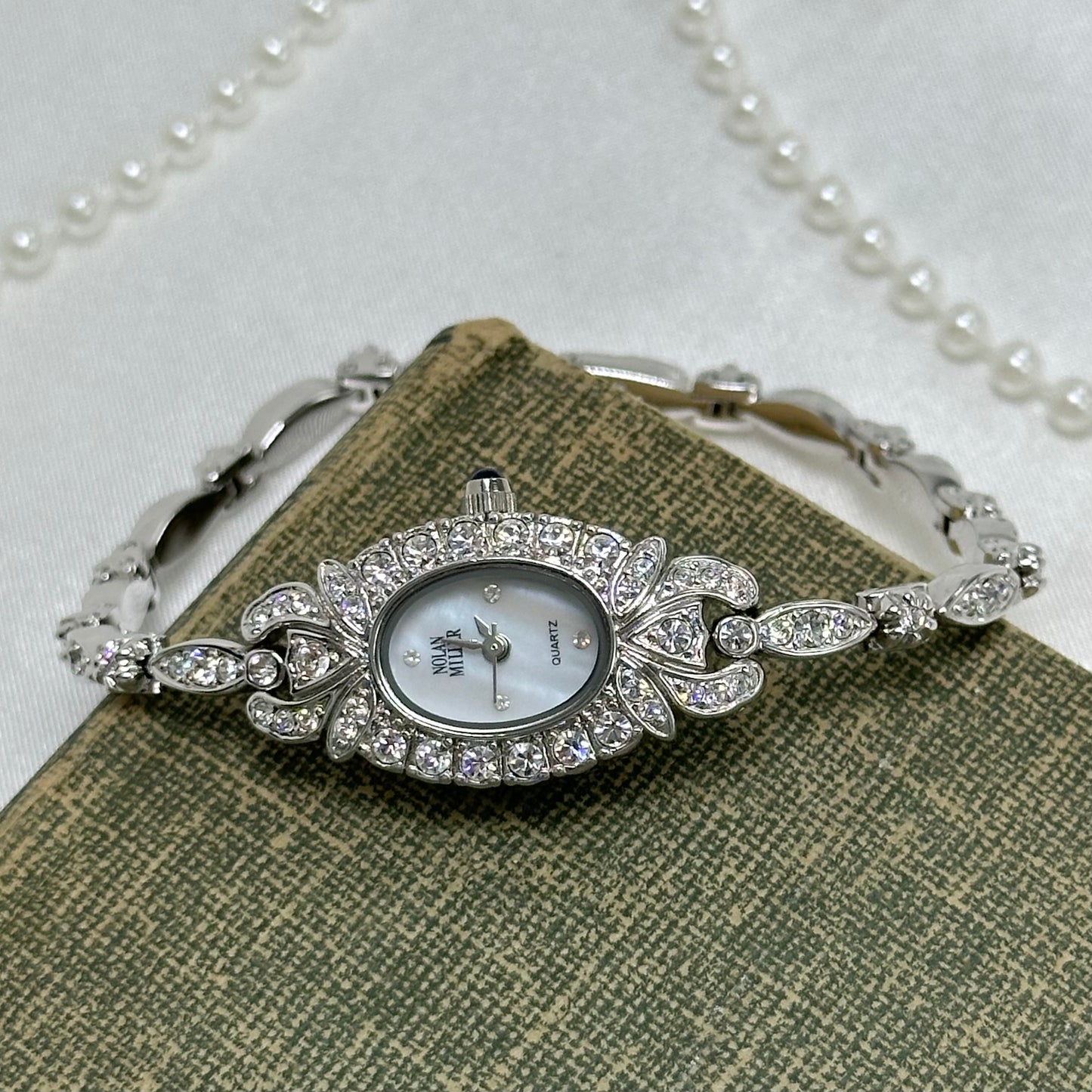 Elegant Crystal Silver Nolan Miller Watch with Mother of Pearl Dial