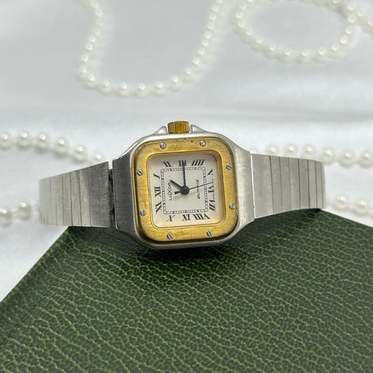 Silver tone LUXOR tank watch with gold tone accents and roman numeral markers.