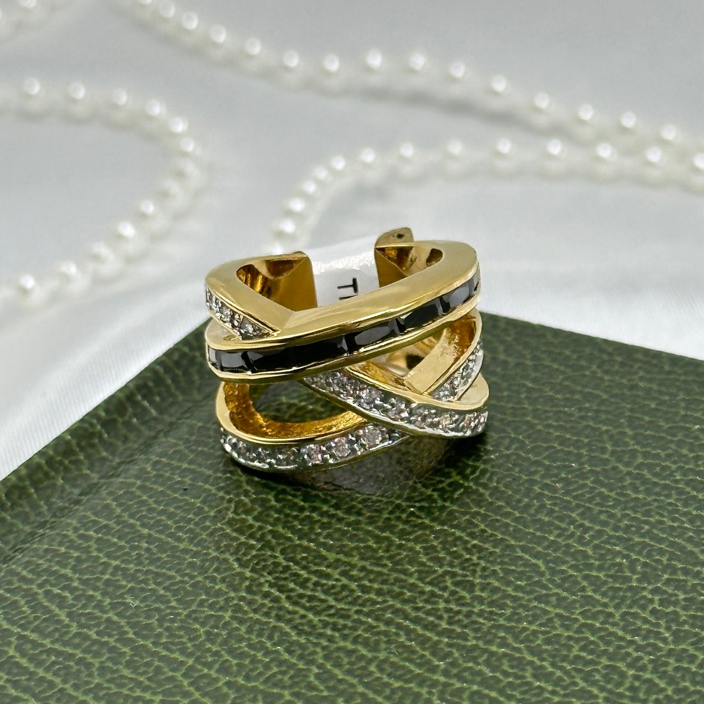 14k gold electroplated vintage deadstock ring with black and white cubic zirconia stones and crisscrossed band.