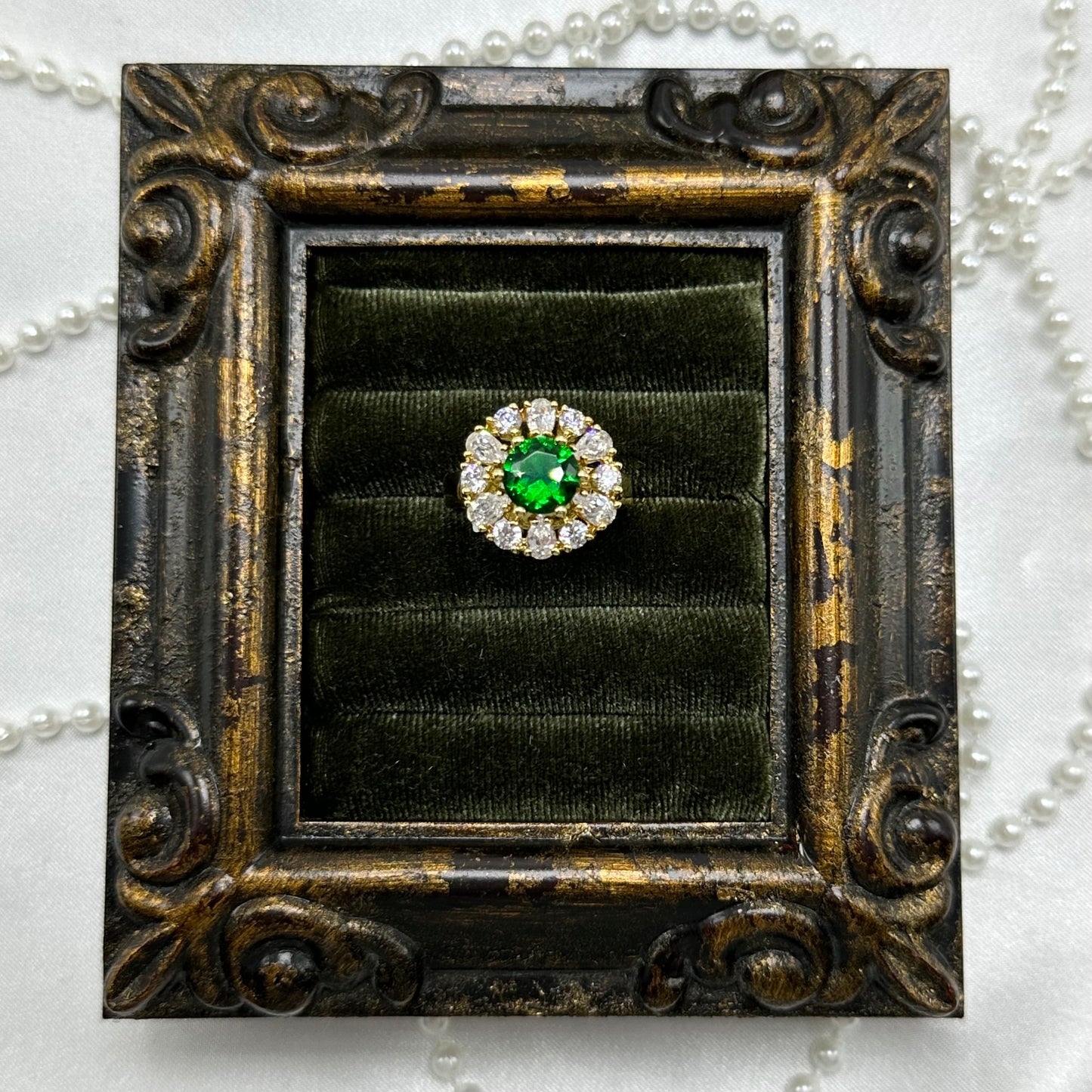 14k gold electroplated vintage deadstock ring with bright green center stone surrounded by cubic zirconia stones.
