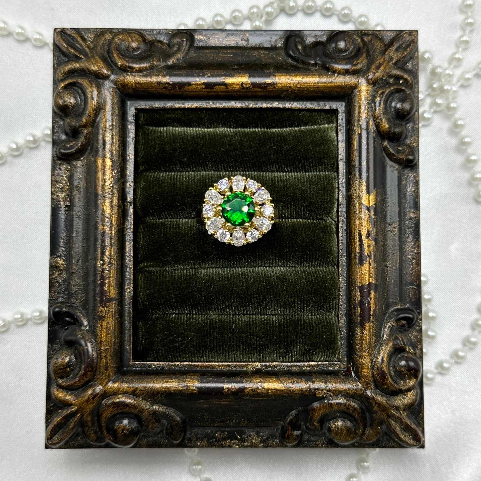 14k gold electroplated vintage deadstock ring with bright green center stone surrounded by cubic zirconia stones.