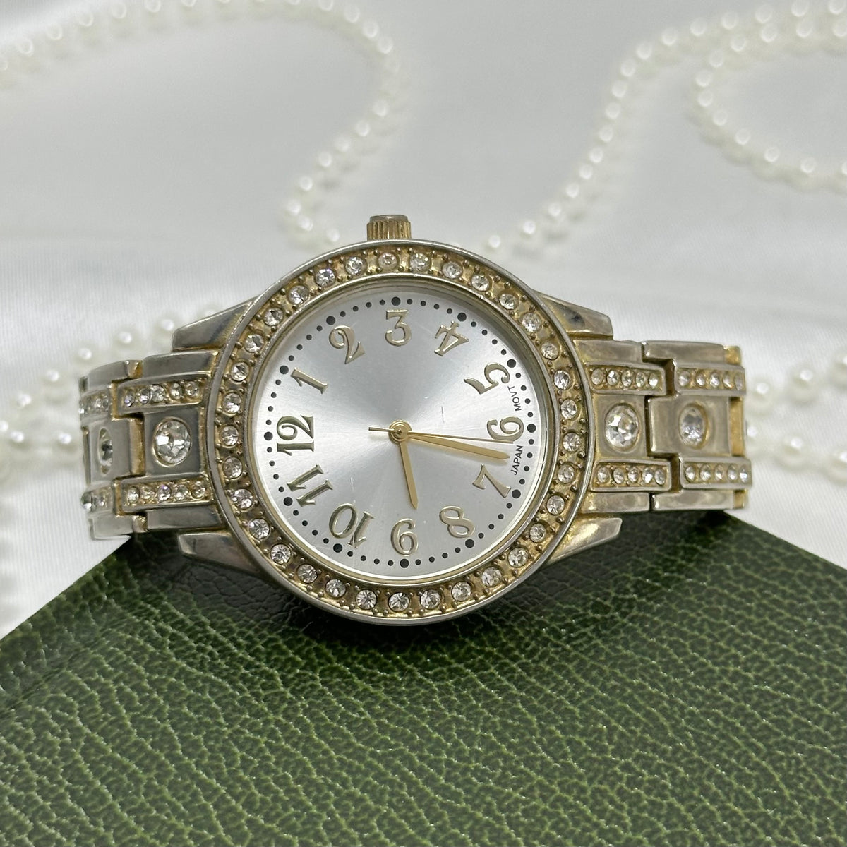 Silver tone watch with diamanté round dial and metal link band.