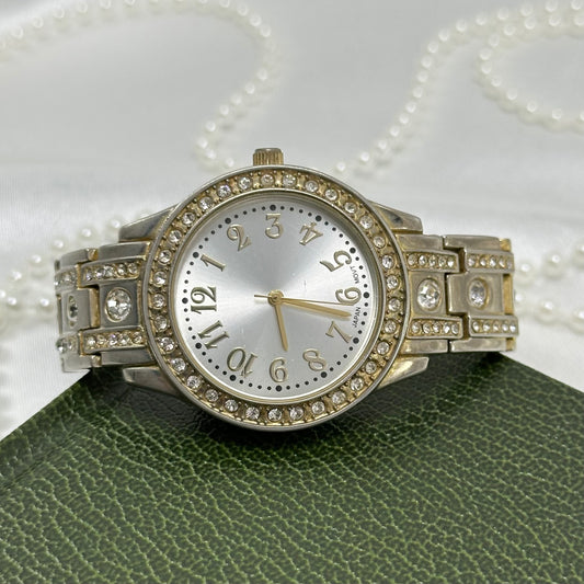 Silver tone watch with diamanté round dial and metal link band.
