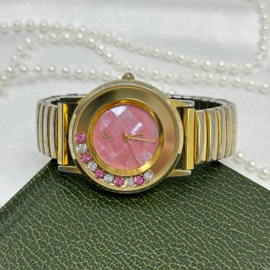 Floating crystal pink dial gold tone TJC watch with pink and clear crystals and stretchable band.