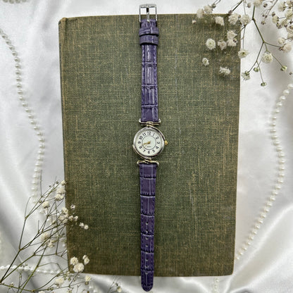 Vintage silver and gold tone watch with purple band and quartz movement