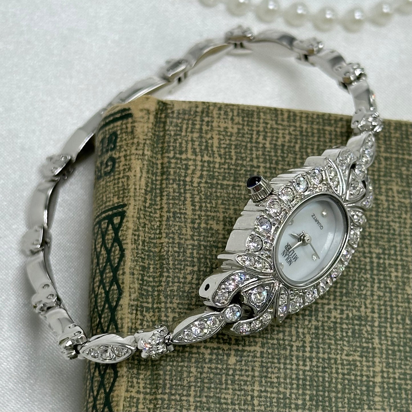 Elegant Crystal Silver Nolan Miller Watch with Mother of Pearl Dial