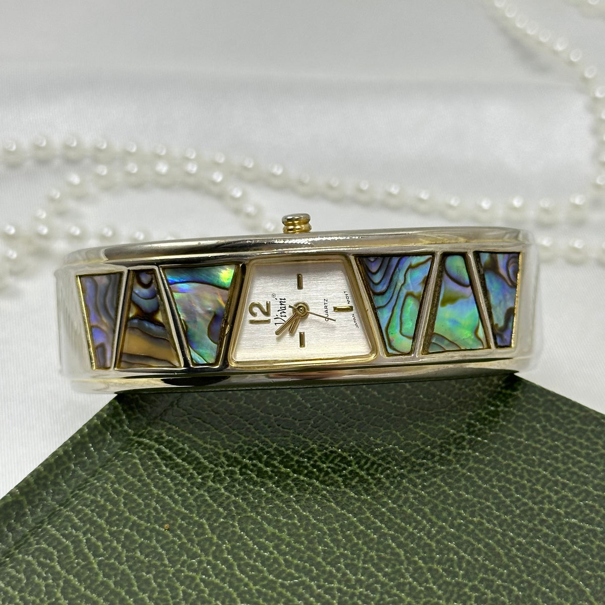 Gold tone cuff Vivani watch with triangle abalone cuff and quartz movement.