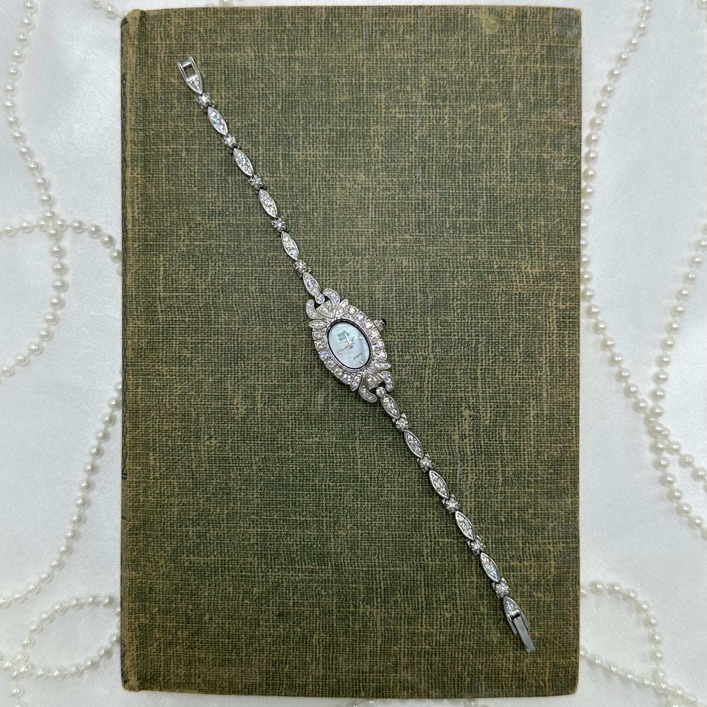 Elegant Crystal Silver Nolan Miller Watch with Mother of Pearl Dial