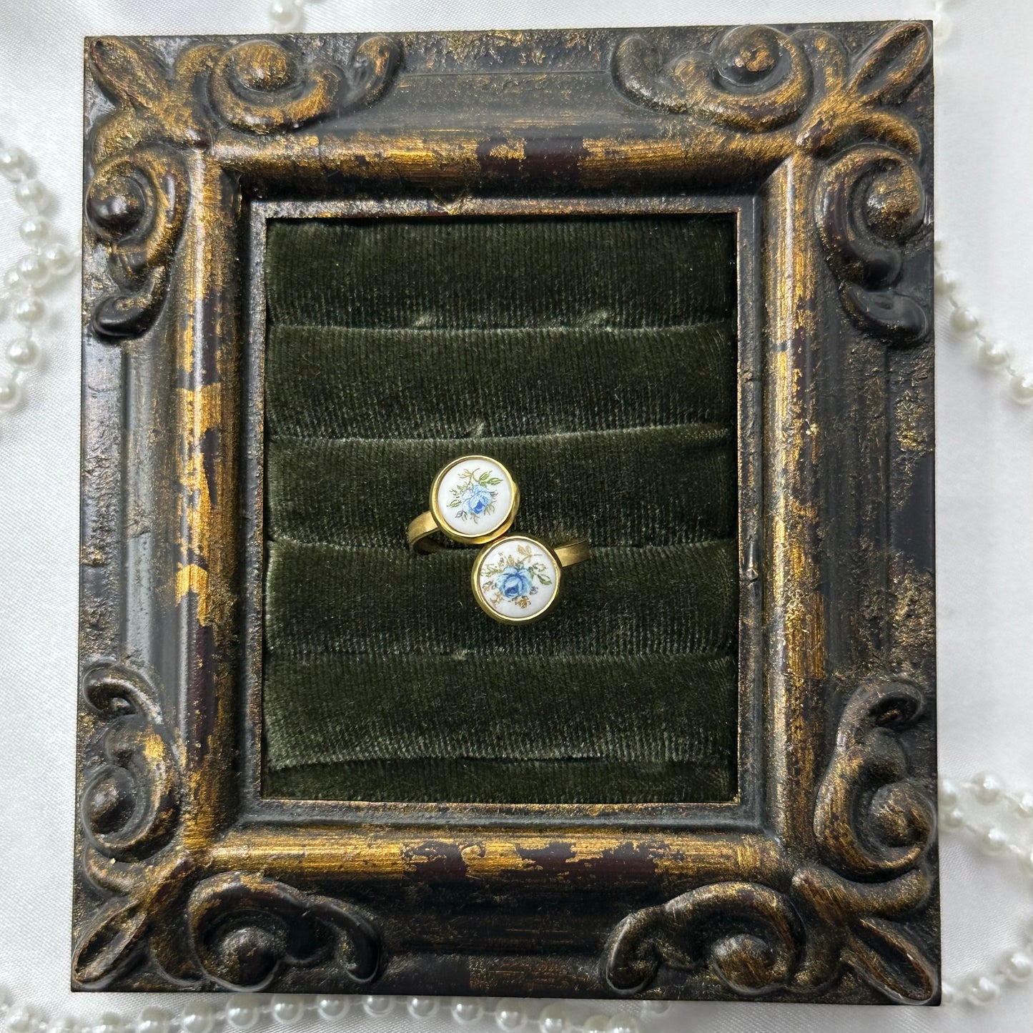 Vintage style gold tone bypass ring with round blue rose painted white enamel cameos.