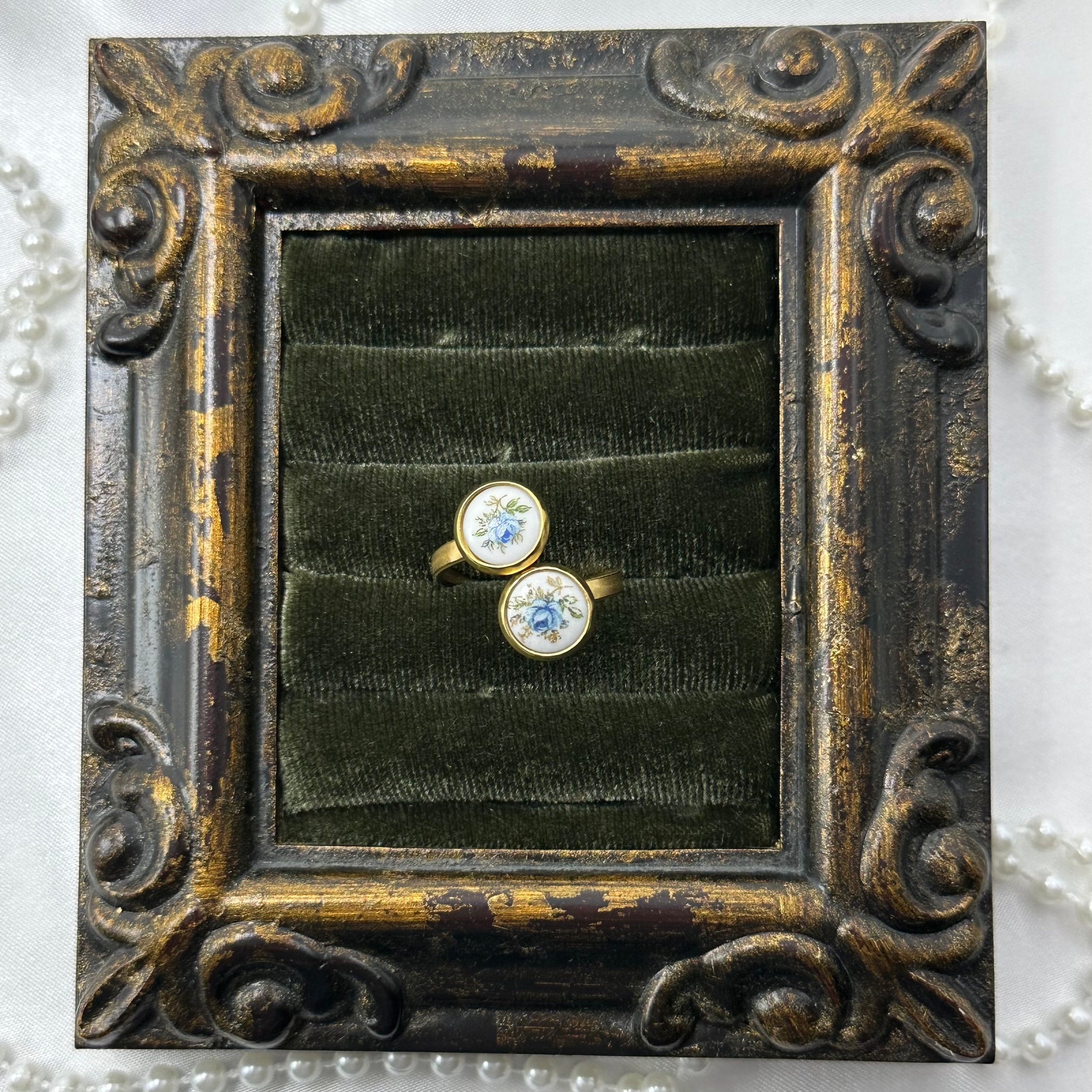 Vintage style gold tone bypass ring with round blue rose painted white enamel cameos.