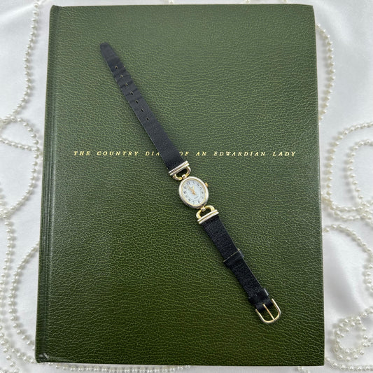 Vintage gold tone Carriage watch with genuine leather black band and oval dial.